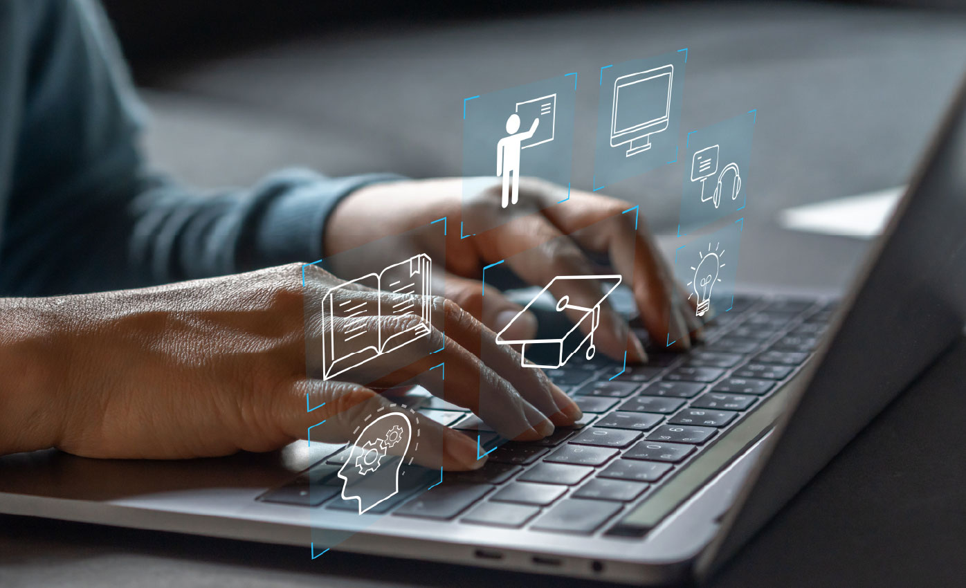 Hands typing on a laptop with digital education icons overlaid. 